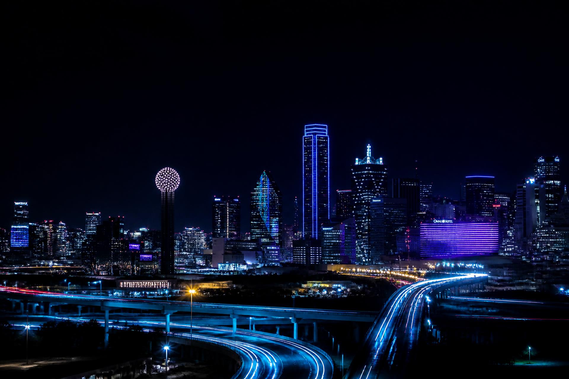 Dallas skyline at night with electric blue light trails